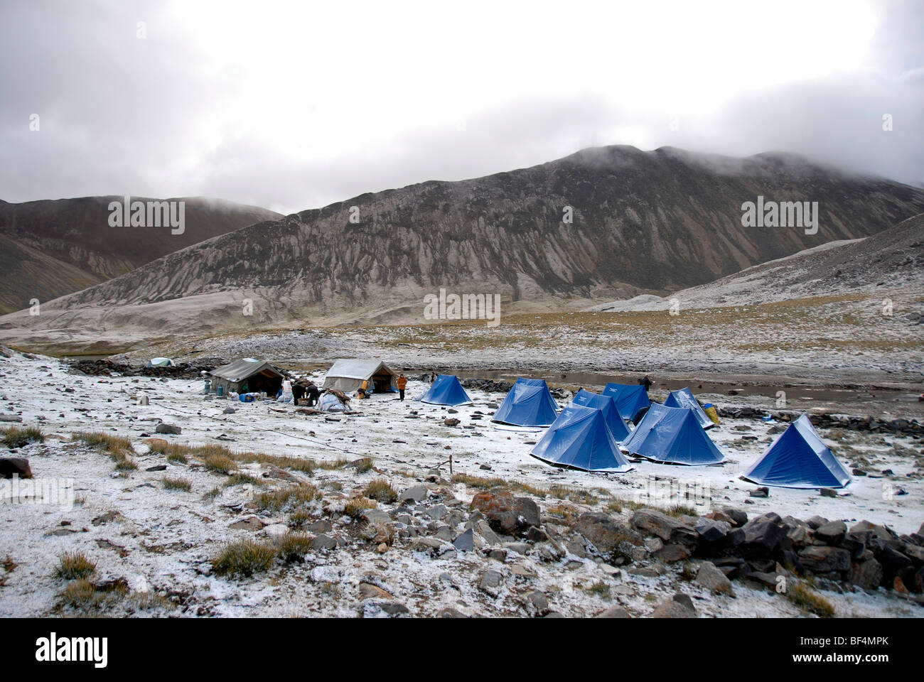 Trekking turismo, camp, tende blu appena scesa la neve, Tsotup-chu valley, un vecchio sentiero dei pellegrini attraverso le alte montagne di Foto Stock