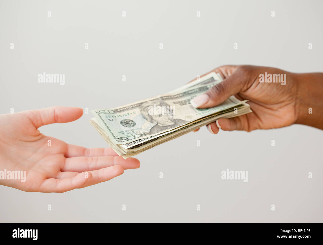 Donna africana consegna stack di 20 fatture del dollaro Foto Stock