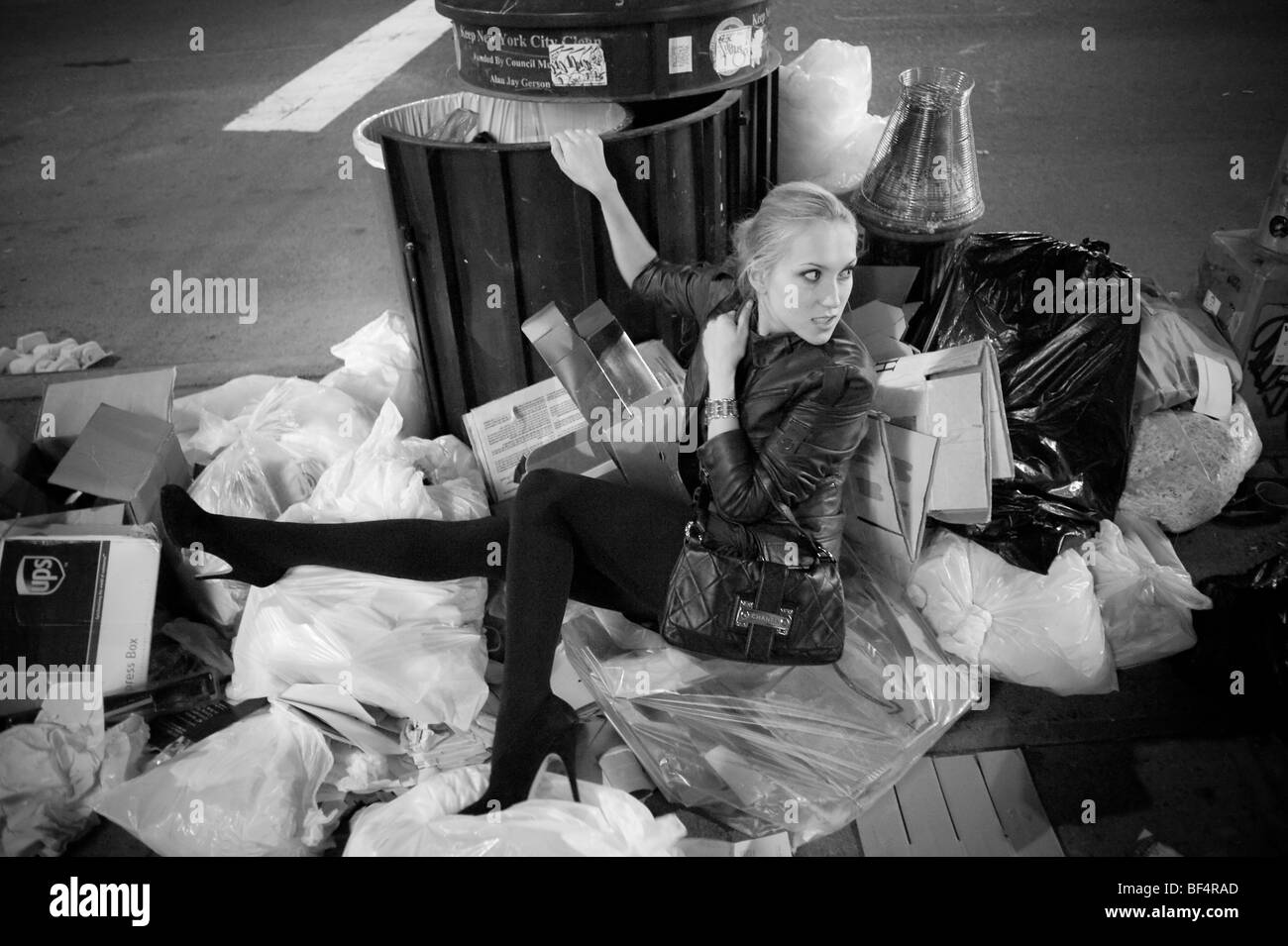 Modello di moda in seduta garbage pila Foto Stock