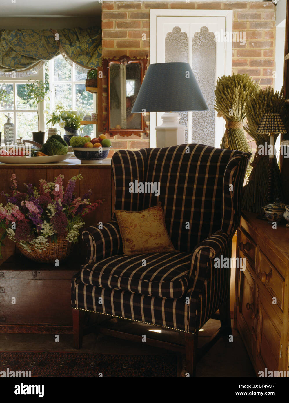 Close-up di dark striped poltroncina in cottage soggiorno con mais-covoni sul petto di cassetti Foto Stock