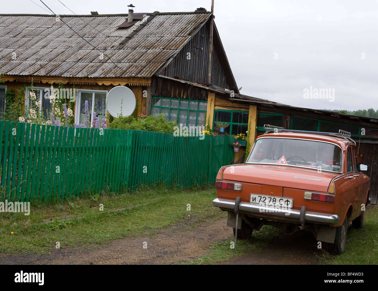 Vintage Lada automobile parcheggiata al di fuori del tradizionale casa rurale, Urali, Russia Foto Stock