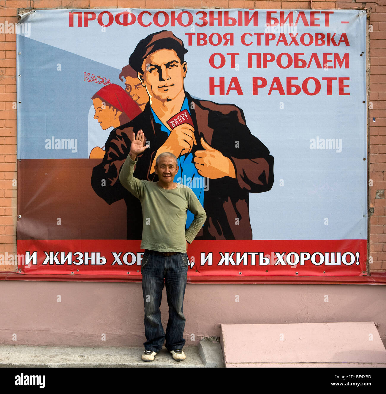 Uomo in piedi nella parte anteriore della tradizionale propaganda sovietica poster, ritratto, Ekaterinburg, negli Urali, Russia Foto Stock