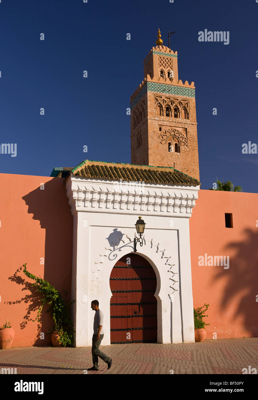 Marrakech, Marocco - uomo cammina da entrata alla Moschea di Koutoubia. Foto Stock