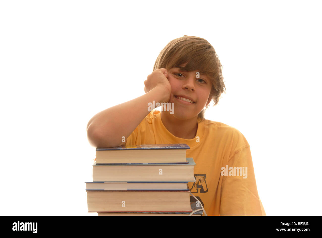 Il ragazzo, 16, appoggiata su una pila di libri, guardando annoiato Foto Stock