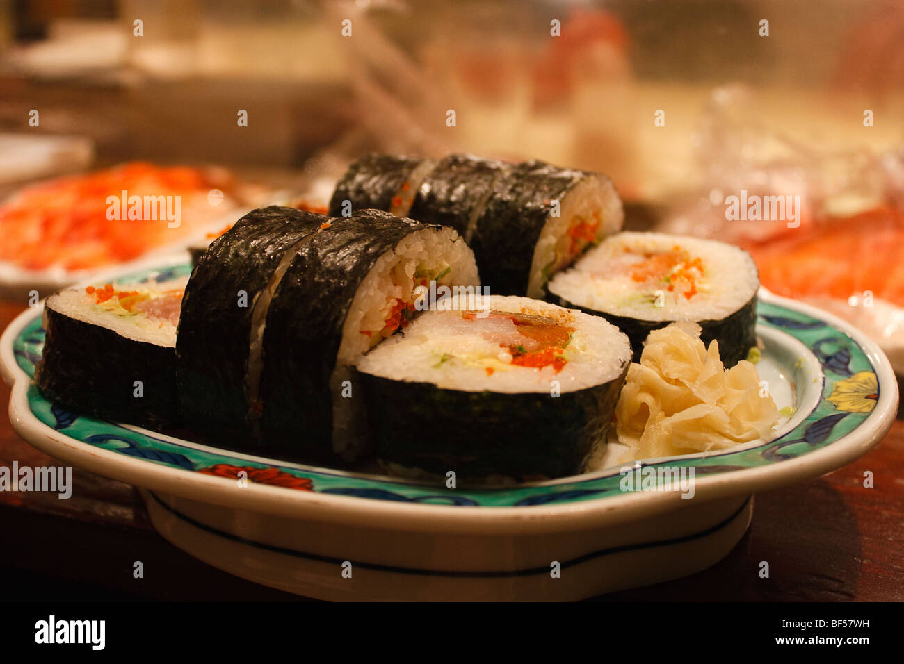 Una deliziosa casa rotolo futomaki sushi con salmone, tonno, barbecue di pelle di salmone, e flying fish roe avvolto con alghe marine all'esterno. Foto Stock