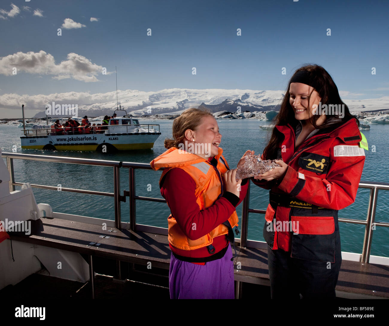 Ragazza di toccare il ghiaccio del ghiacciaio, Jokulsarlon laguna glaciale, Islanda Foto Stock