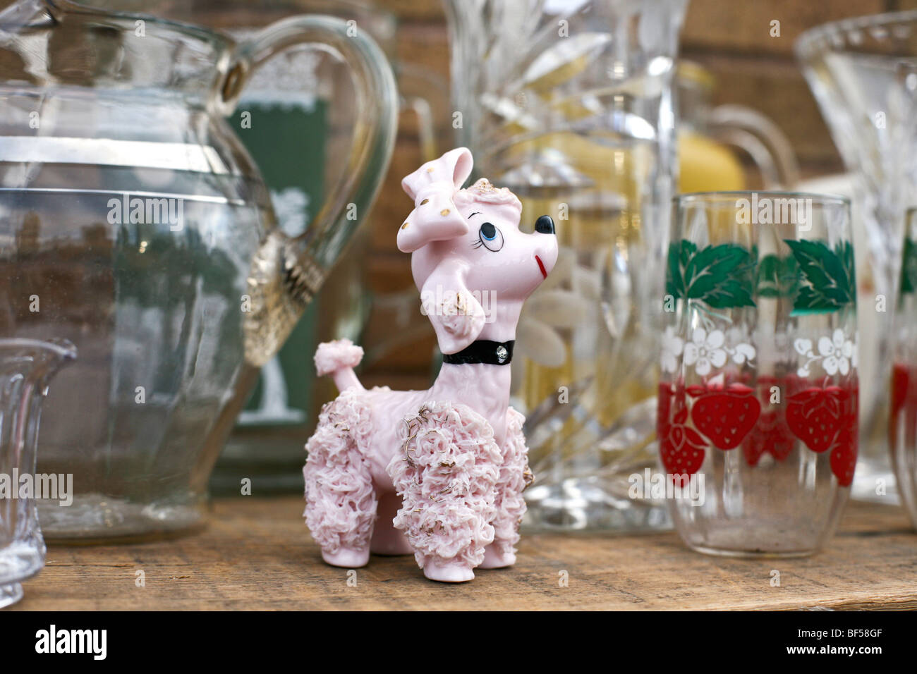 Il kitsch di figurine di vetro vispo pink poodle con accenti d'oro esposti per la vendita a Hells Kitchen mercato delle pulci di New York City Foto Stock