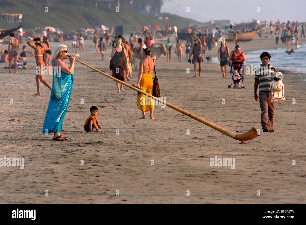 Donna giocare corno delle alpi sulla spiaggia, Arambol, Goa, India, Asia del Sud Foto Stock