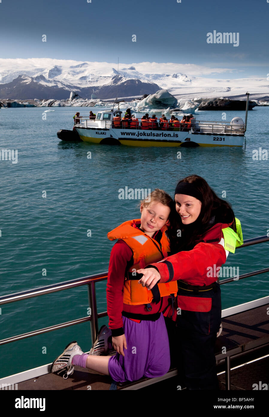 Ragazza che puntano a guarnizioni di tenuta sul viaggio in barca, Jokulsarlon laguna glaciale, Islanda Foto Stock