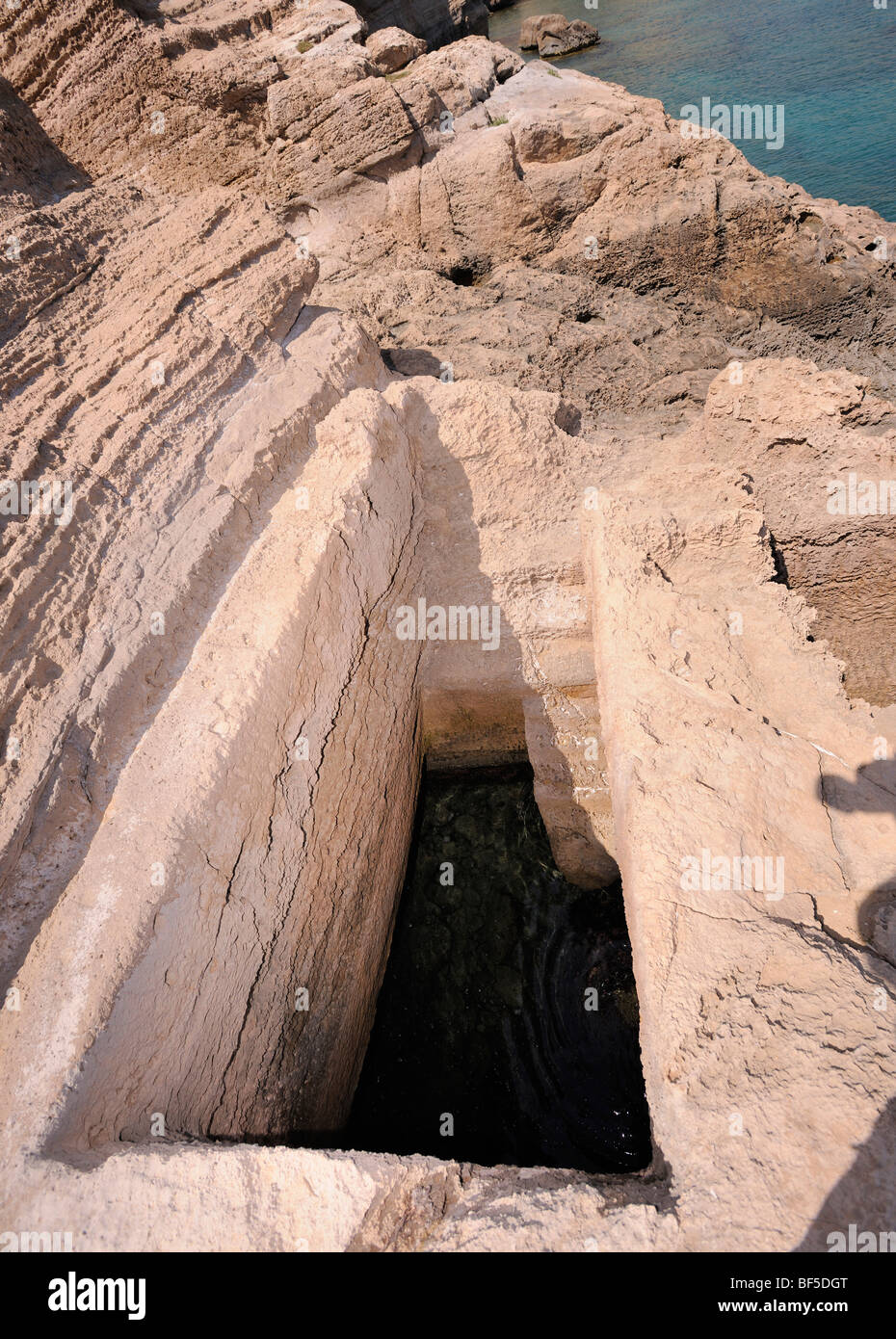 Piscina roccia scolpita con collegamento sotterraneo al mare, forse utilizzato come un serbatoio di pesce, Cape Fourni, Rodi, Grecia, Europa Foto Stock