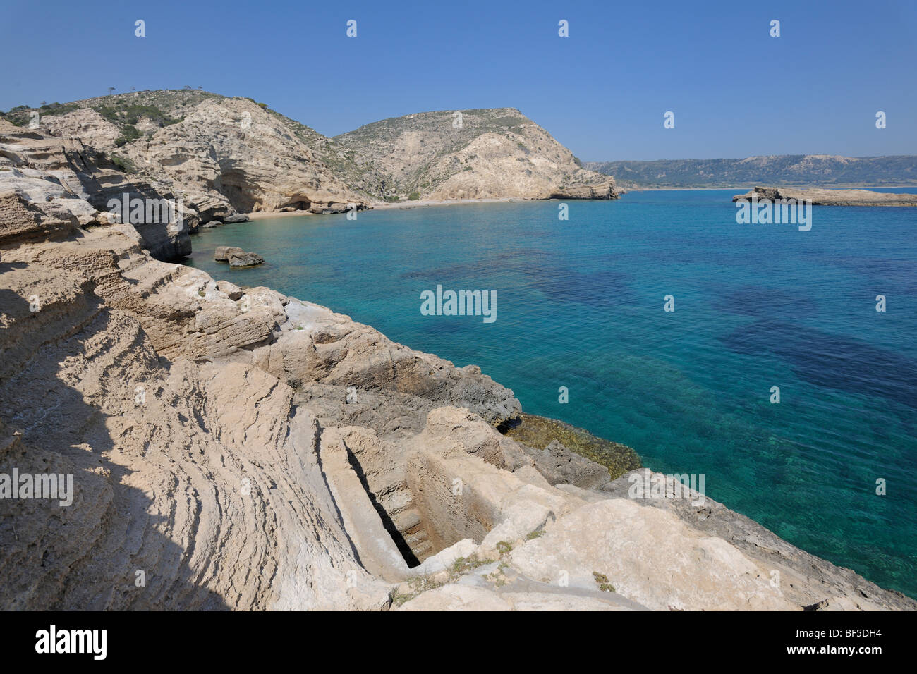 Piscina roccia scolpita con collegamento sotterraneo al mare, forse utilizzato come un serbatoio di pesce, Cape Fourni, Rodi, Grecia, Europa Foto Stock