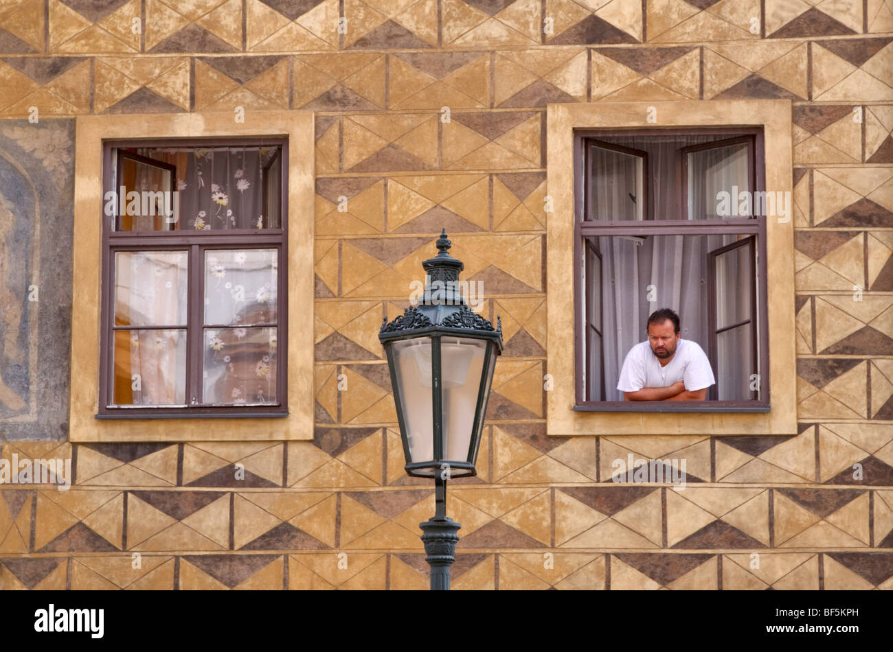 Uomo che guarda fuori dalla finestra, Praga, Repubblica Ceca Foto Stock