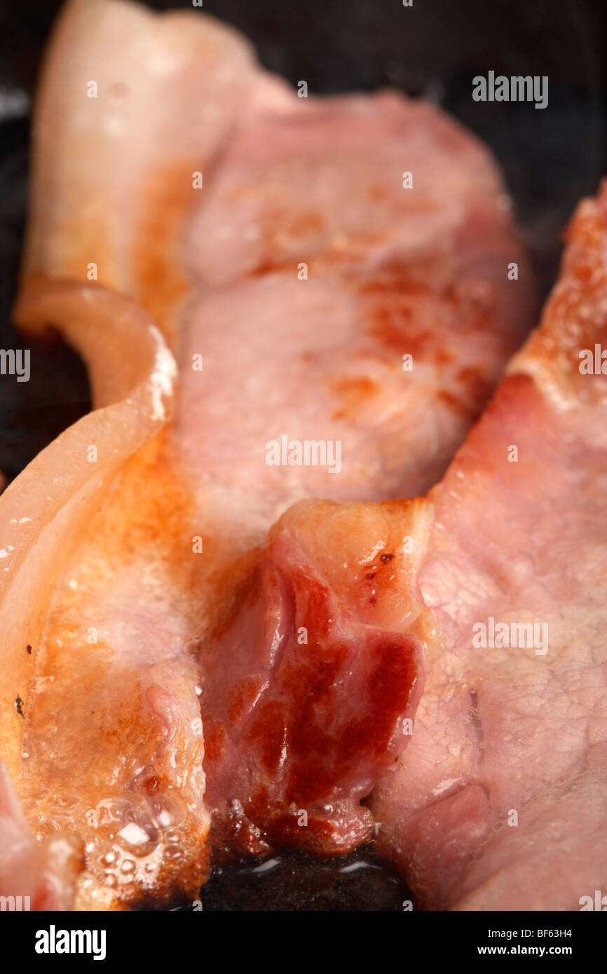 Materie back bacon dal british organico a doppio spiovente suini allevati in Irlanda una cottura in padella Foto Stock