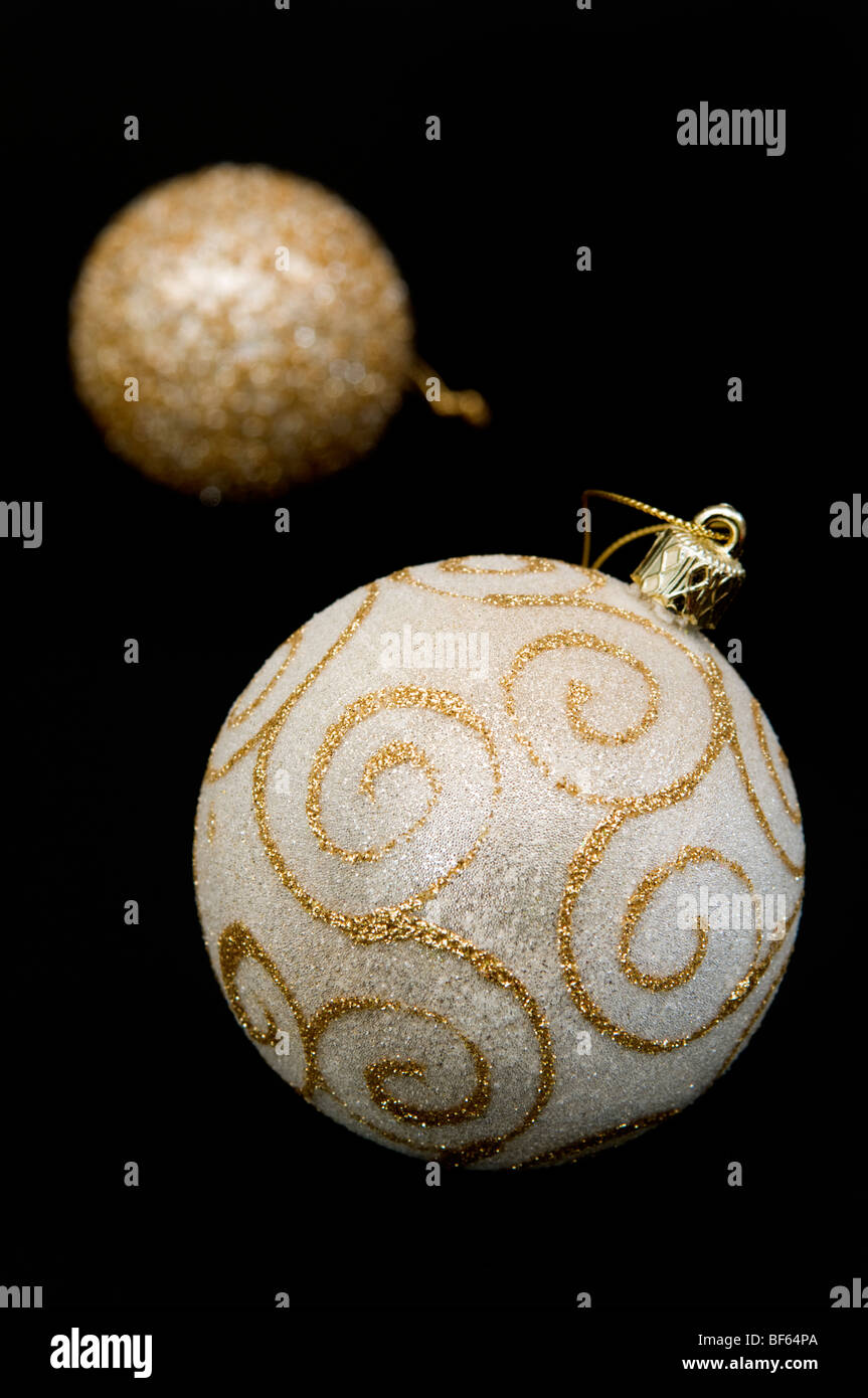 Close up di color oro ninnolo decorativo con fuori fuoco ninnolo dietro su sfondo nero Foto Stock