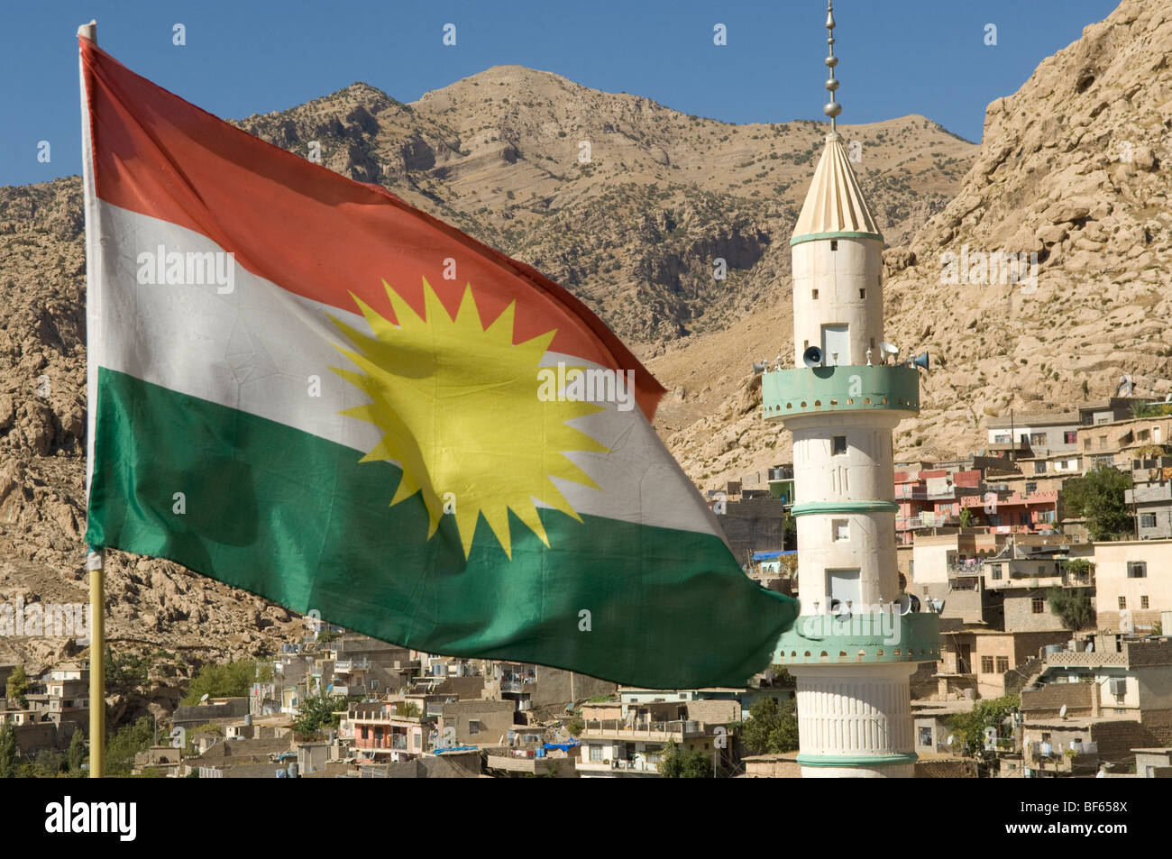 Bandiera curda volando sopra il villaggio di montagna Kurdistan iracheno Foto Stock