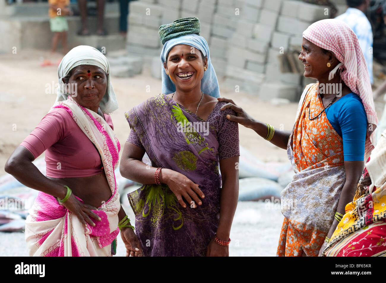 Le donne indiane lavorando sulle strade ridendo e scherzando insieme. Puttaparthi, Andhra Pradesh, India Foto Stock