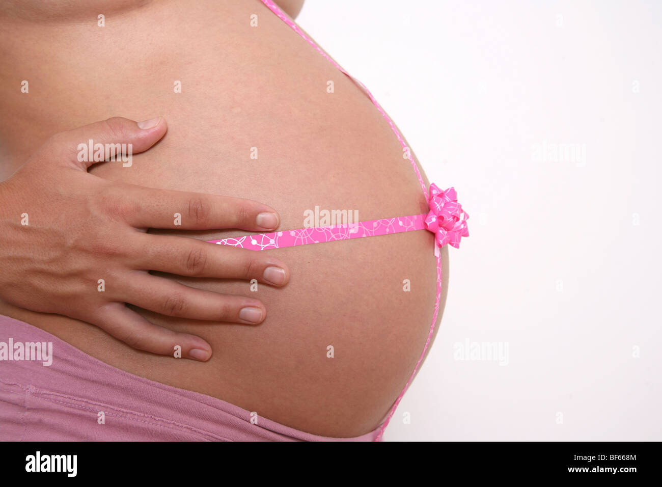 Donna incinta avvolto grande pancia in nastri per celebrare il nuovo arrivo Foto Stock