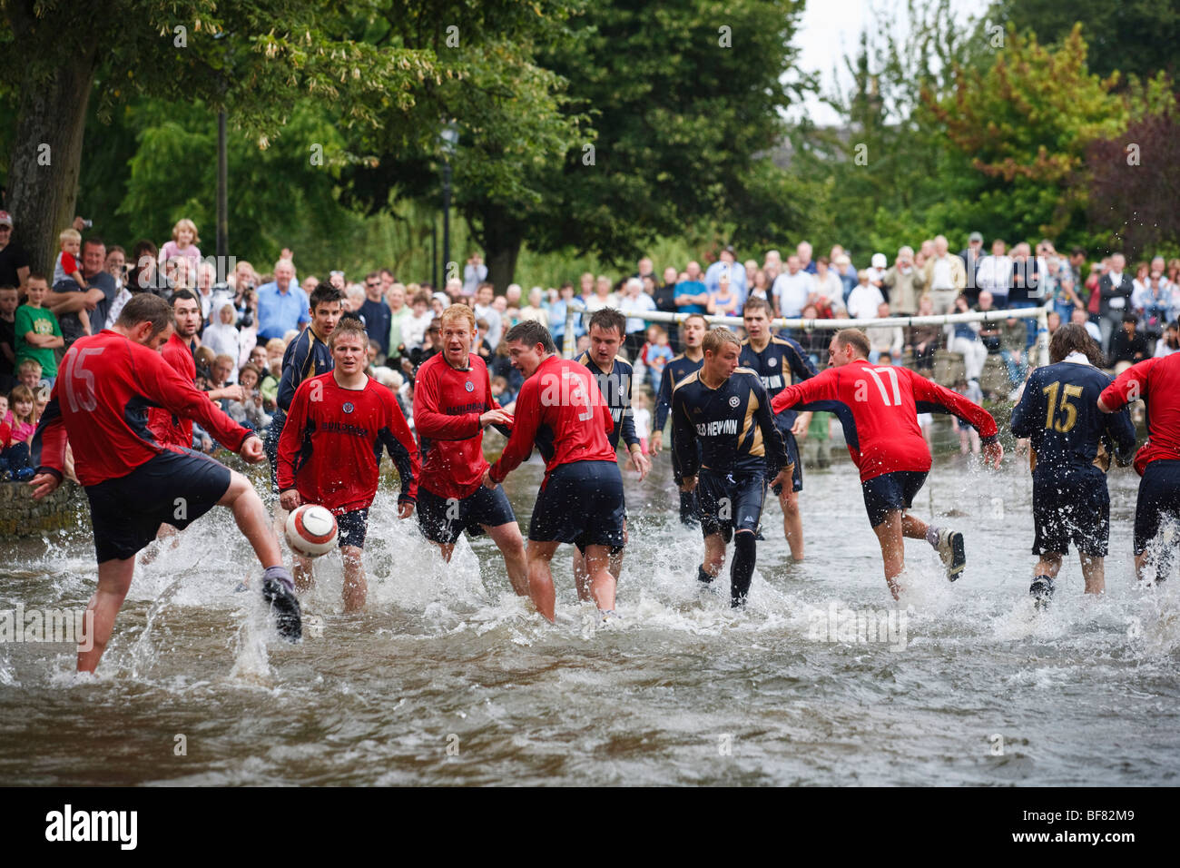 Il gioco d'acqua - una partita di calcio nel Fiume Windrush svolge ogni Ferragosto, Bourton-on-the-acqua, REGNO UNITO Foto Stock