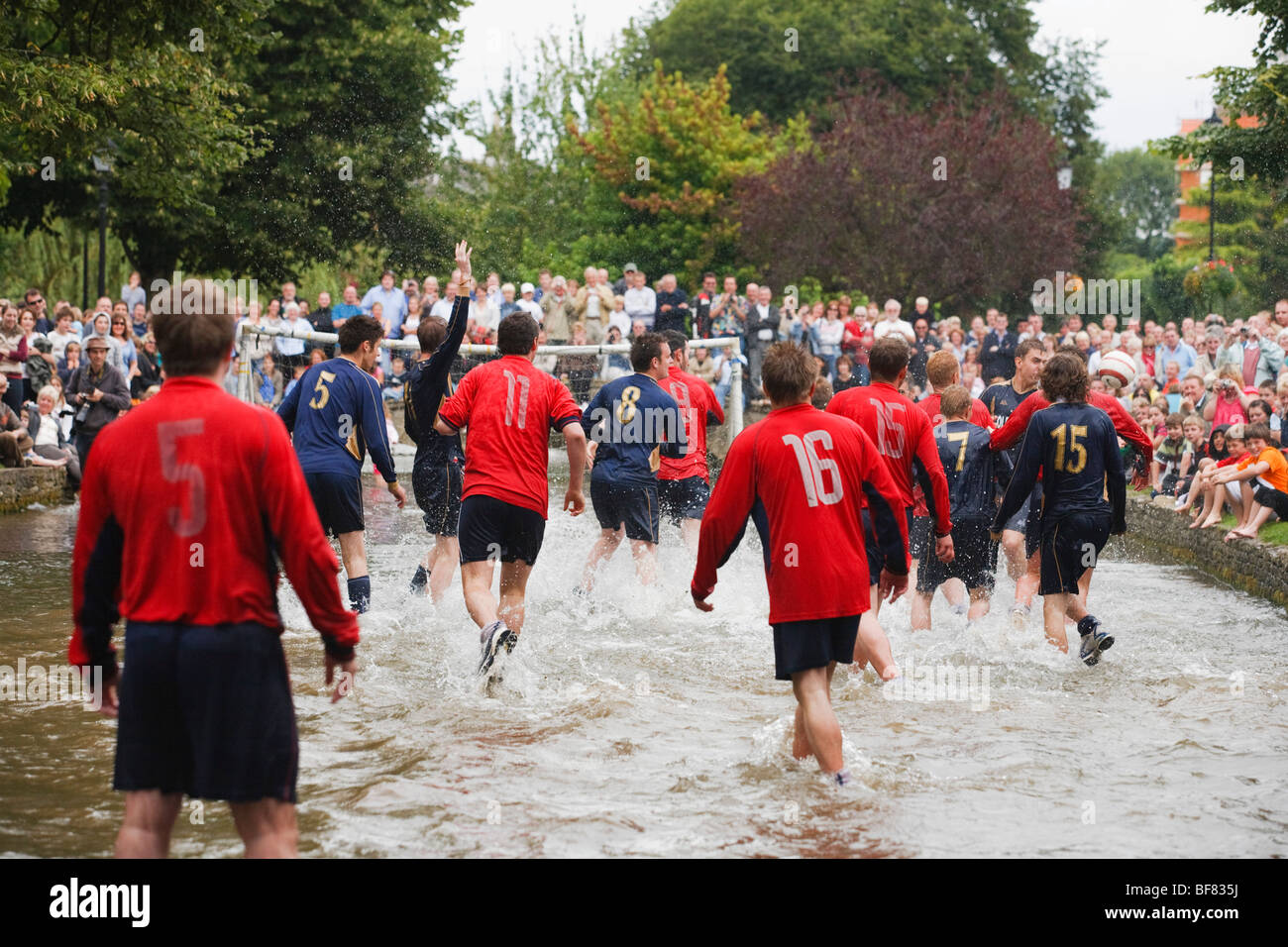 Il gioco d'acqua - una partita di calcio nel Fiume Windrush svolge ogni Ferragosto, Bourton-on-the-acqua, REGNO UNITO Foto Stock
