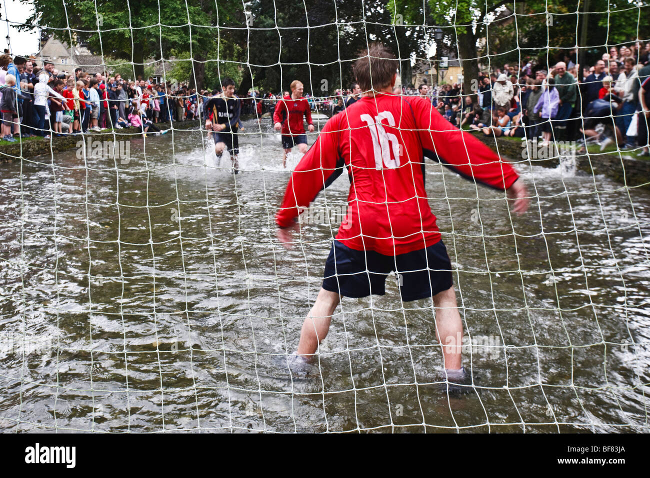 Il gioco d'acqua - una partita di calcio nel Fiume Windrush svolge ogni Ferragosto, Bourton-on-the-acqua, REGNO UNITO Foto Stock