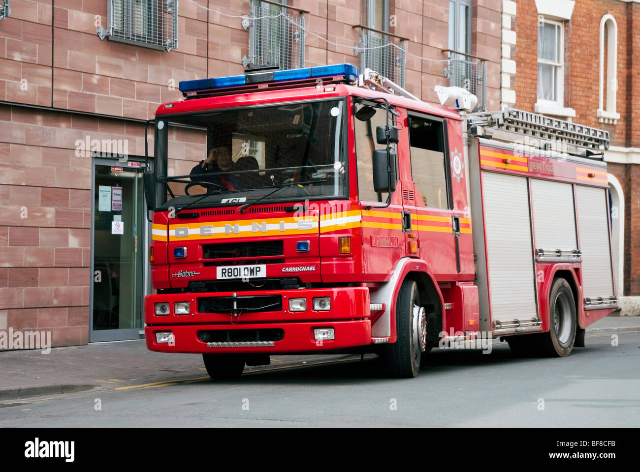 Motore Fire, UK. Dennis red fire-motore parcheggiato in una strada della città su una chiamata di routine. Foto Stock