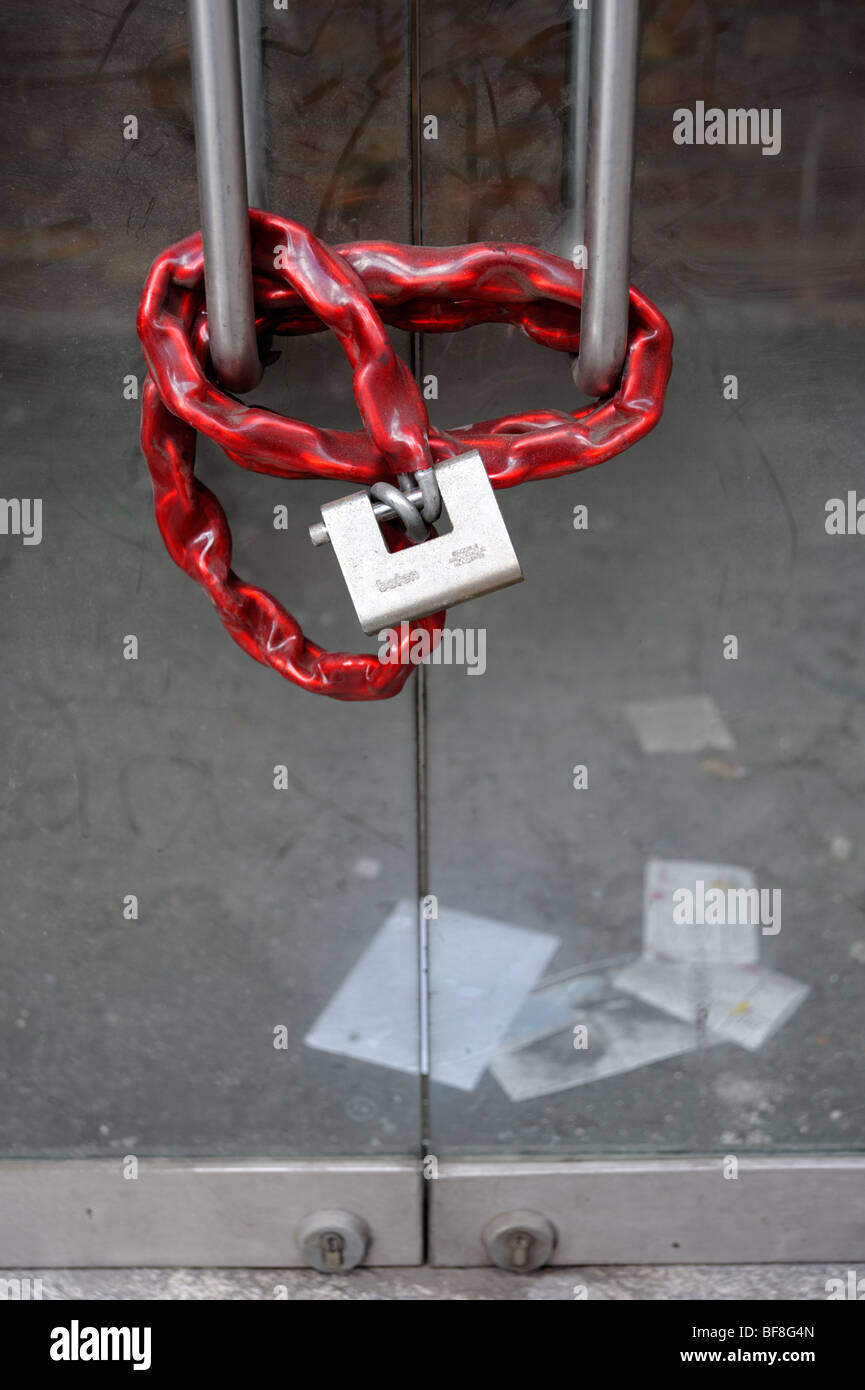 Il lucchetto e catena sul negozio chiuso ingresso. Londra. Regno Unito 2009. Foto Stock