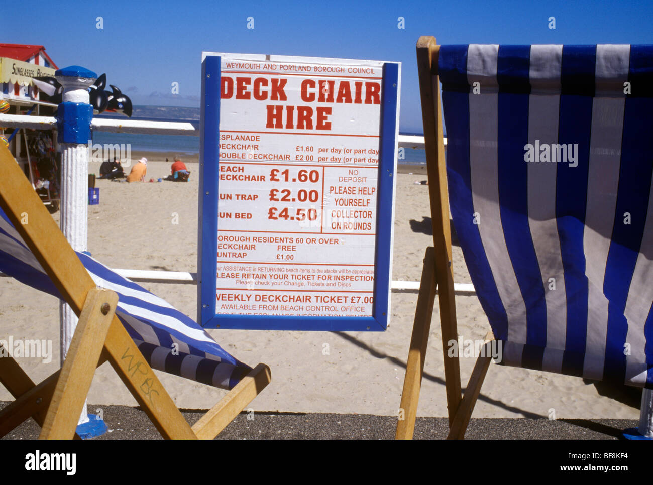 Weymouth Dorset UK scena dalla passeggiata sulla spiaggia segno per il noleggio di sedie a sdraio legato su ringhiere tra due sedie Foto Stock