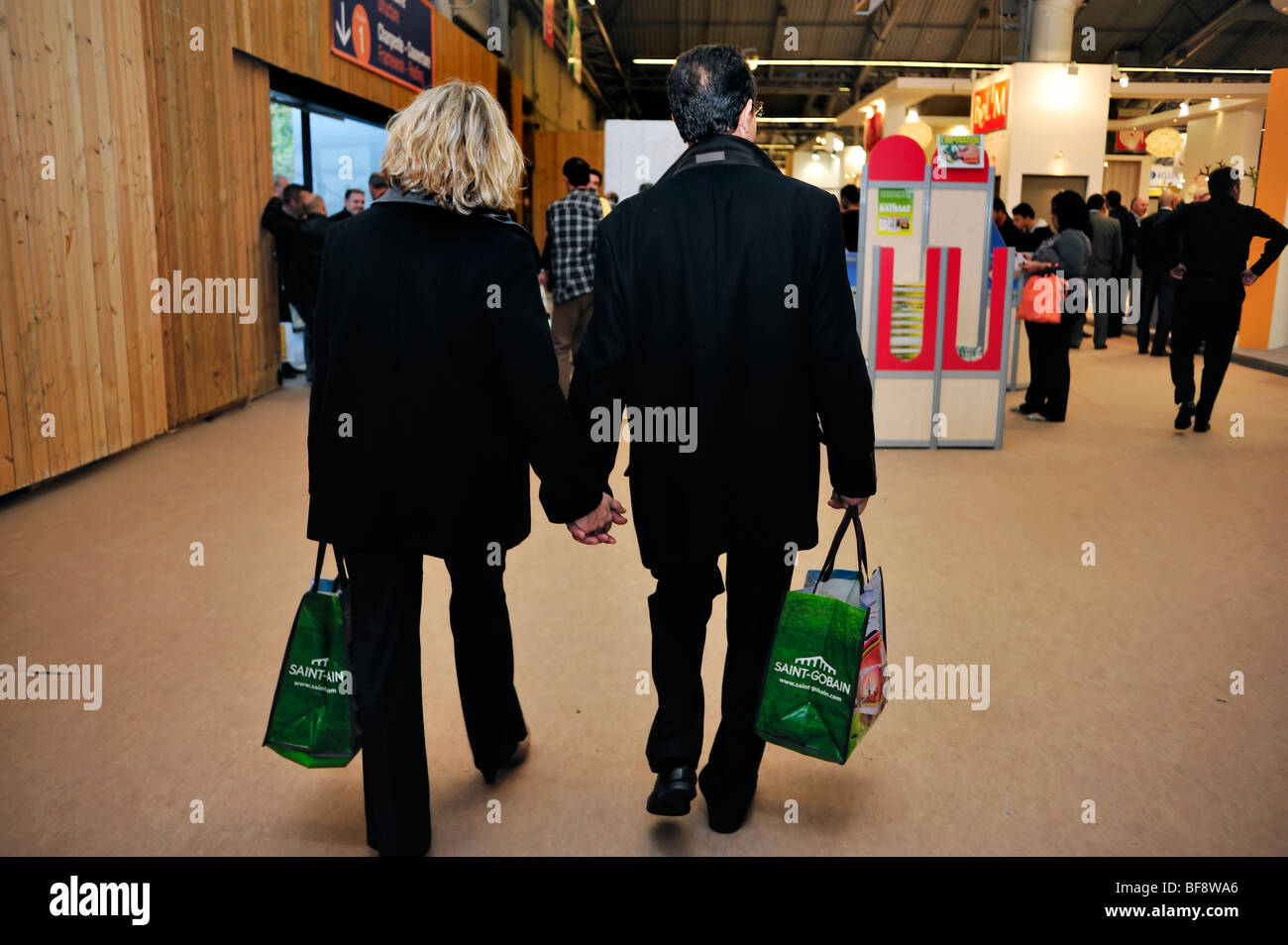 Parigi, Francia, Construction Equipment Trade Show, 'salon Batimat', uomo d affari e una donna giovane Holding Hands, a piedi Foto Stock