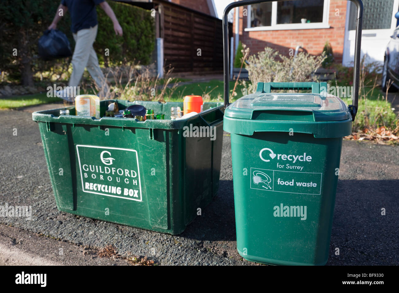 Green marciapiede contenitori per il riciclaggio del vetro e dei rifiuti alimentari in attesa di raccolta al di fuori di una casa. Surrey in Inghilterra UK Gran Bretagna Foto Stock