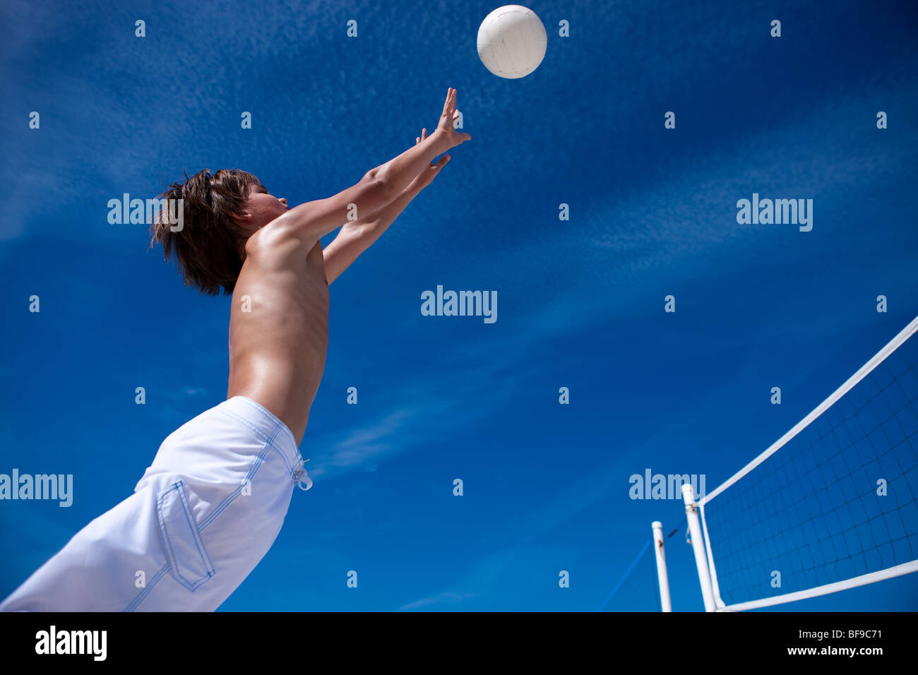 Bruna giovane ragazzo giocando a pallavolo Foto Stock