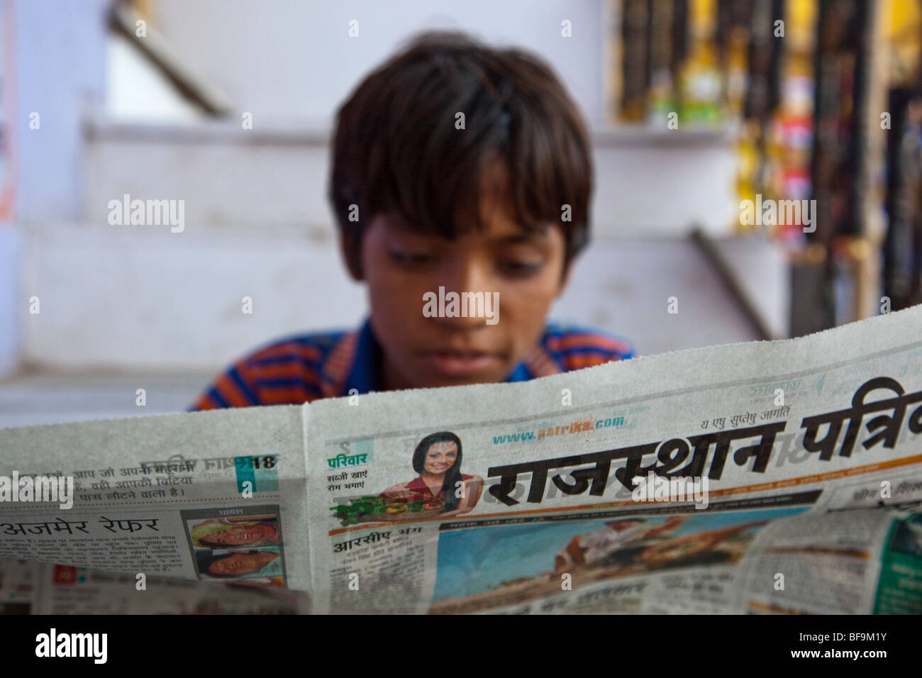 Ragazzo indiano leggendo un giornale in Pushkar nel Rajasthan in India Foto Stock