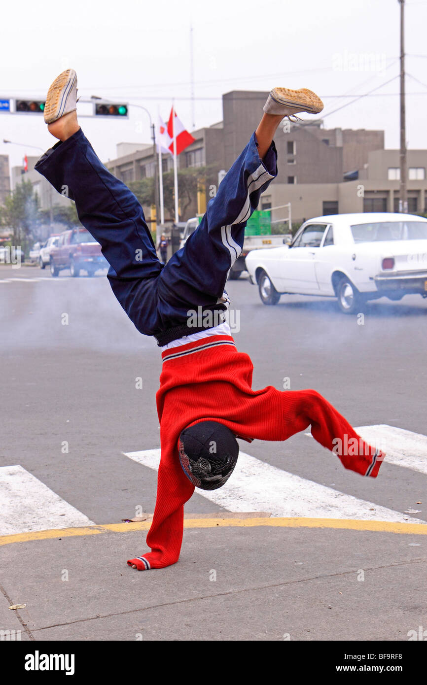 Giovane ragazzo facendo un handstand nelle strade di Lima, Perù Foto Stock