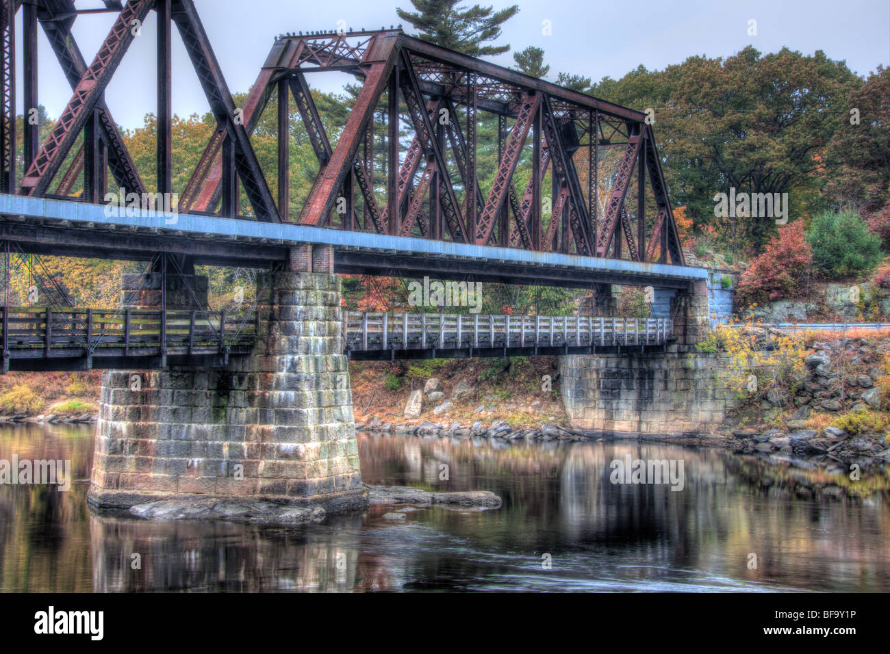 La storica libera ponte nero, una travatura reticolare attraverso il pin collegato a ponte, attraversa il fiume Androscoggin sul Maine Ferrovia Centrale Foto Stock