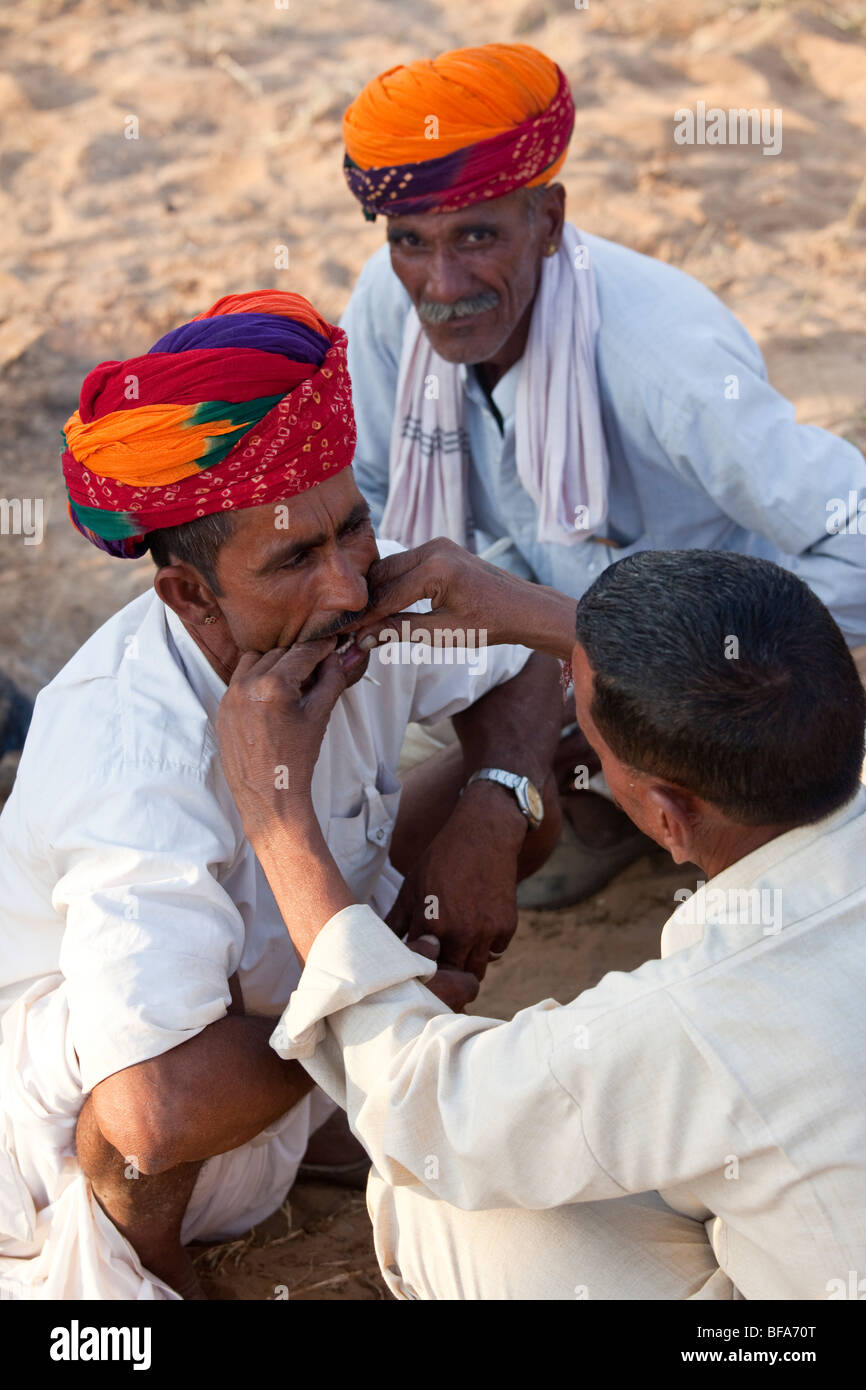 Rajput ricevente il lavoro del dentista al Camel Fair in Pushkar India Foto Stock