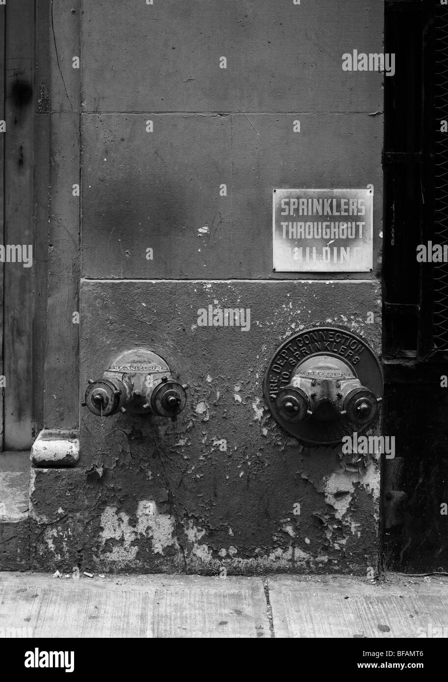 New York, antincendio a sprinkler punti di attacco all'esterno dell'edificio Foto Stock