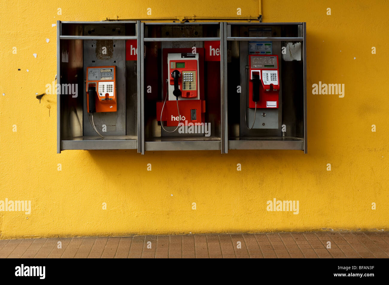 Tre telefoni pubblici su una parete gialla in la citta' di Kuah di Langkawi, Malesia. Foto di Gordon Scammell Foto Stock