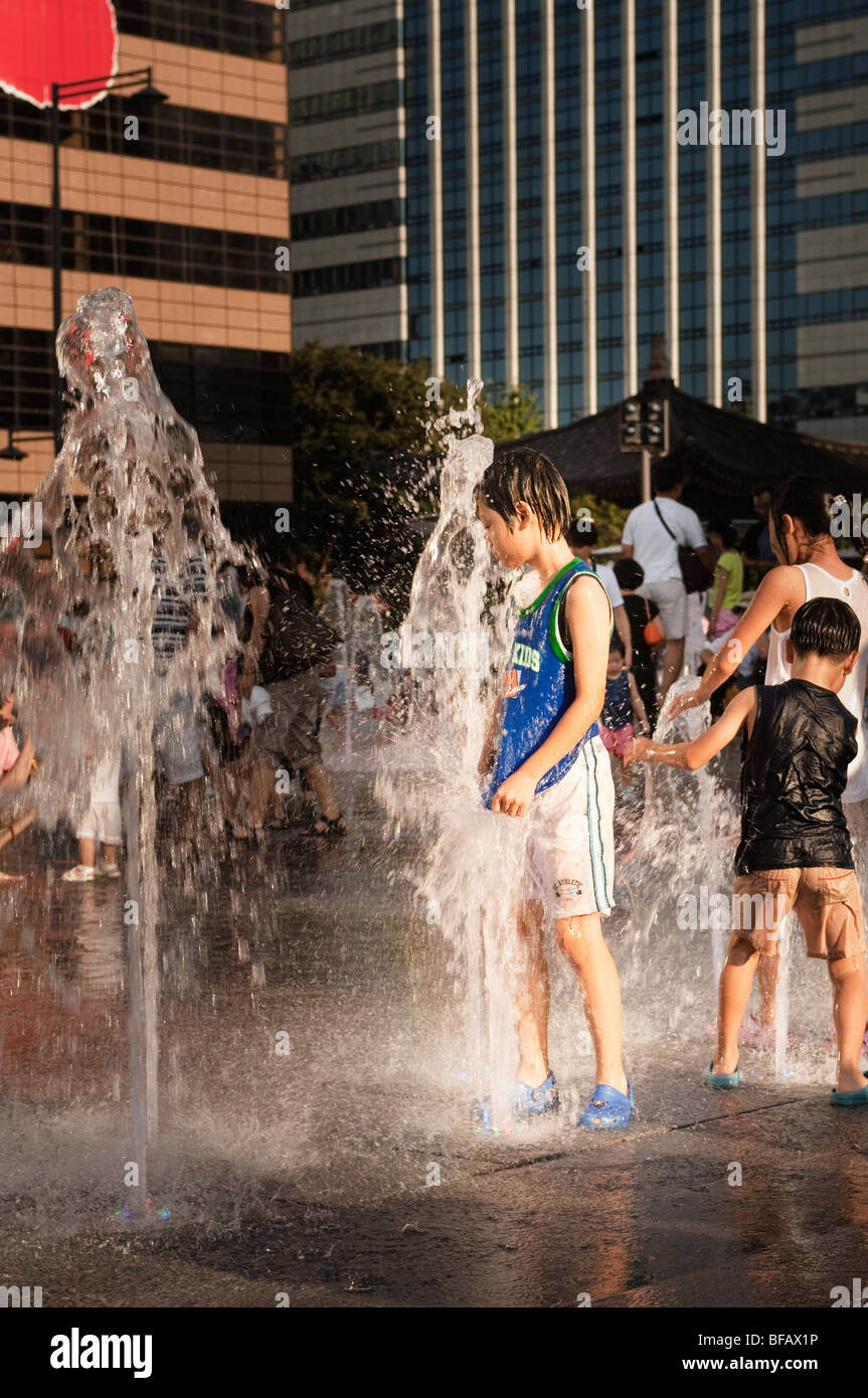 Bambini che giocano con le fontane a Gwanghwamun Plaza a Seul, in Corea del Sud. Foto Stock