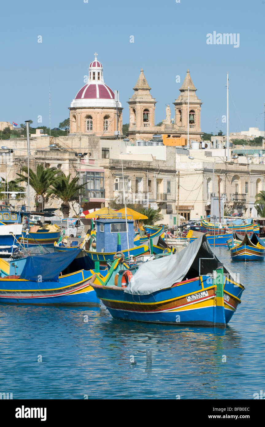 I tradizionali colorati di barche da pesca e i ristoranti a Marsaxlokk Malta. Foto Stock