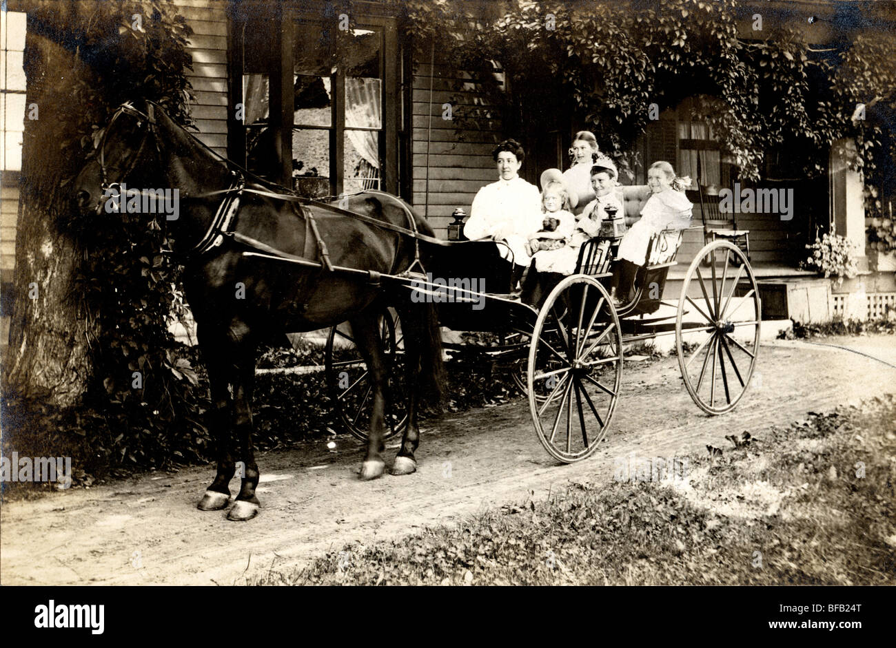 Madre e quattro figli in carrozzella Foto Stock