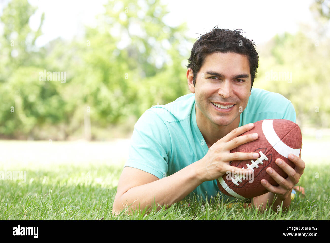 Ritratto di giovane uomo nel parco con il football americano Foto Stock