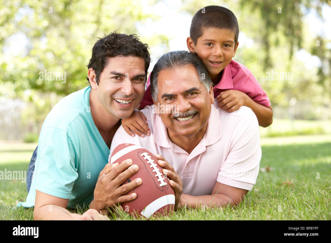 Nonno con figlio e nipote in posizione di parcheggio con il football americano Foto Stock