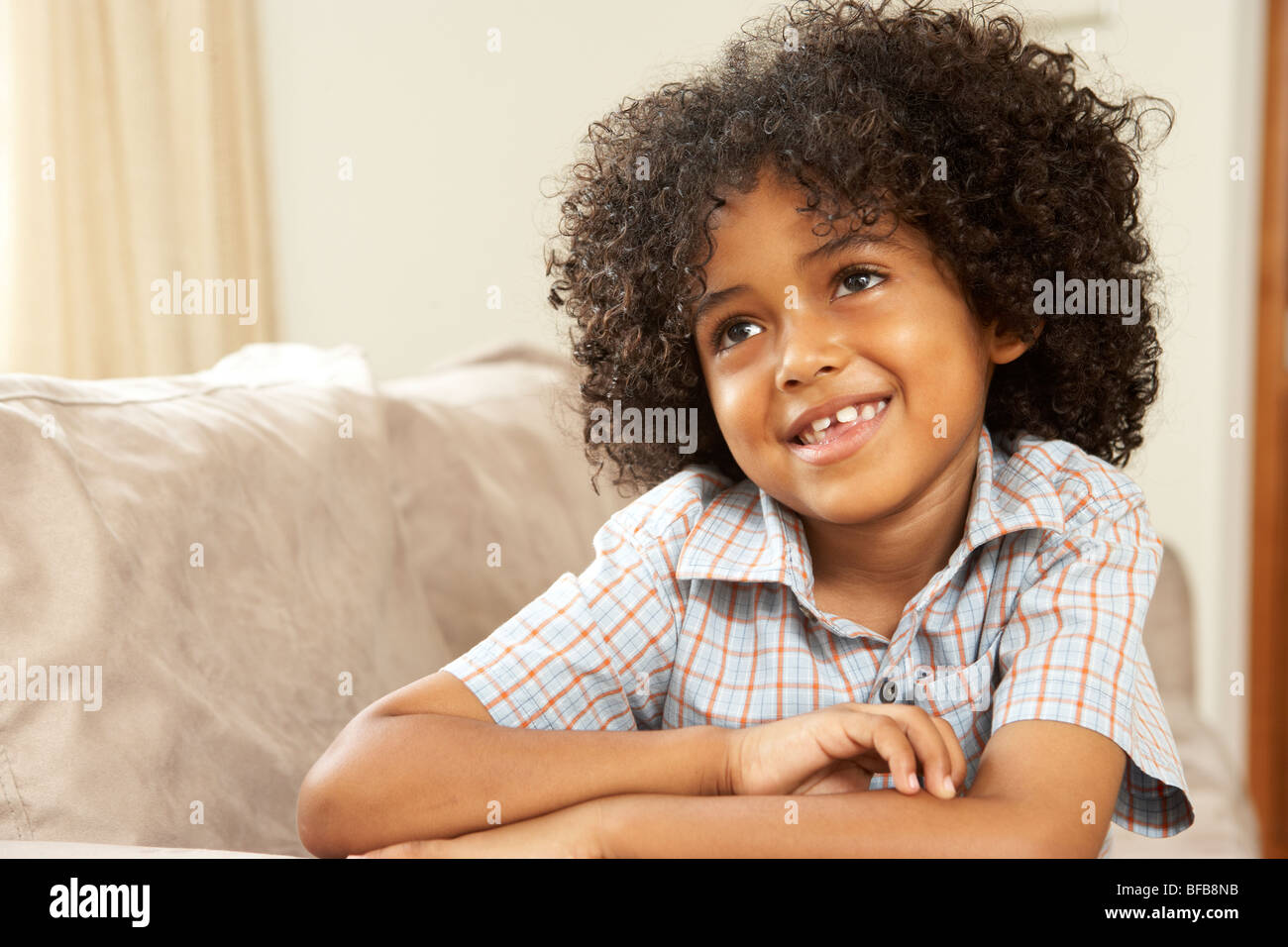Ragazzo giovane rilassante sul divano di casa Foto Stock