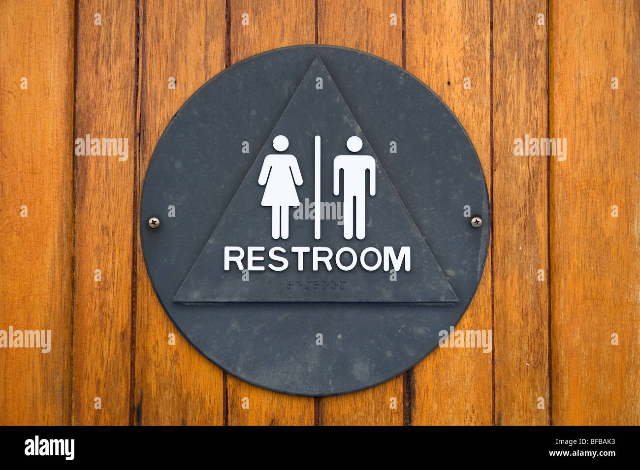 Un vecchio marine restroom unisex segno fatto di marinaio di ottone è attaccato a un legno teak porta. Foto Stock