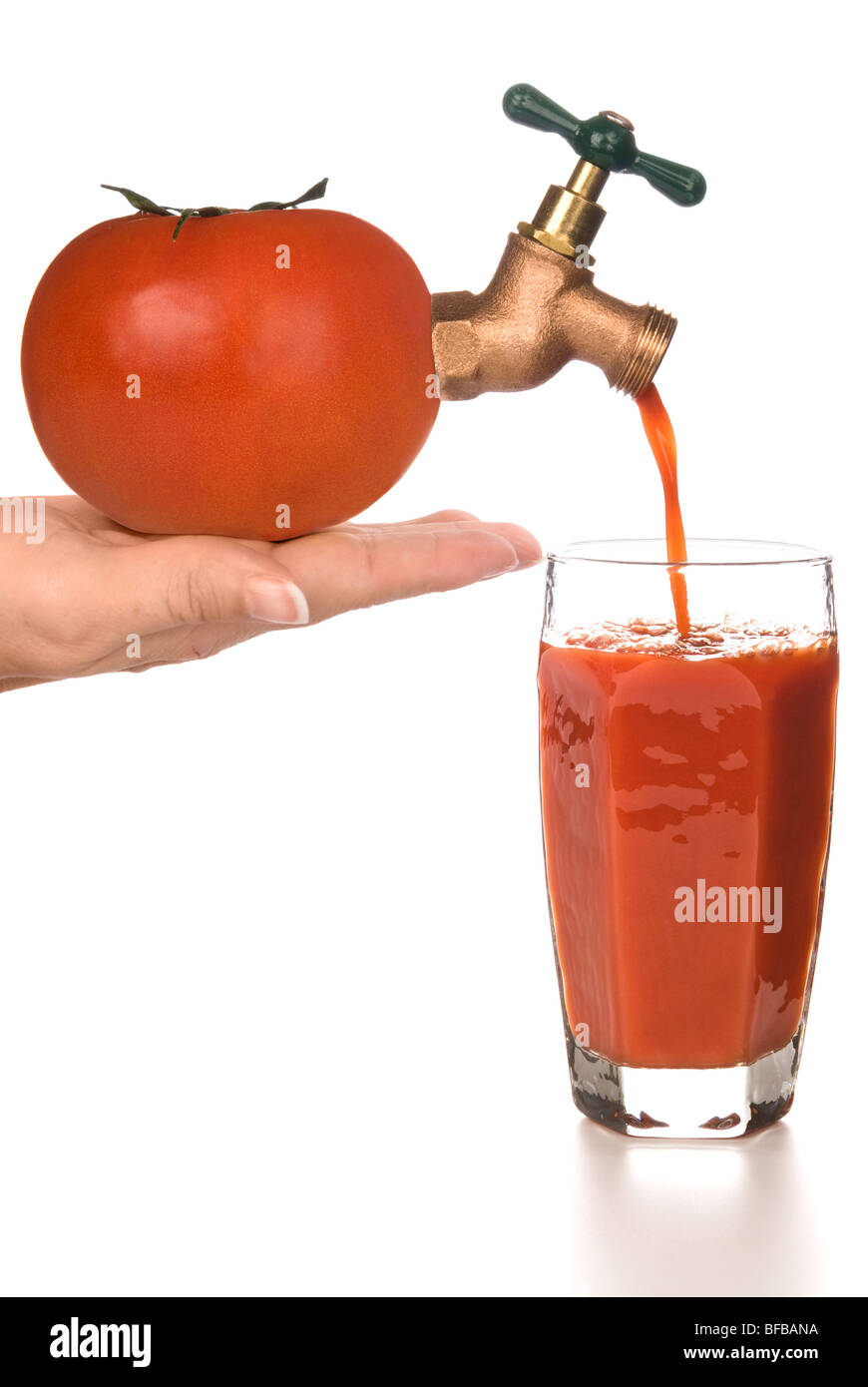 Un fresco bicchiere di succo di pomodoro che viene erogato attraverso una imboccatura dal pomodoro. Foto Stock