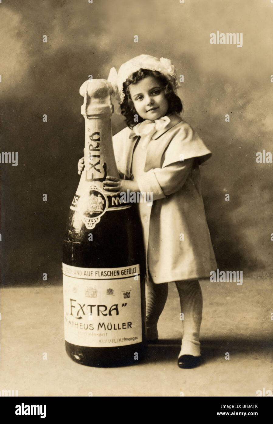 Bambina con immensa Bottiglia di Champagne Foto Stock