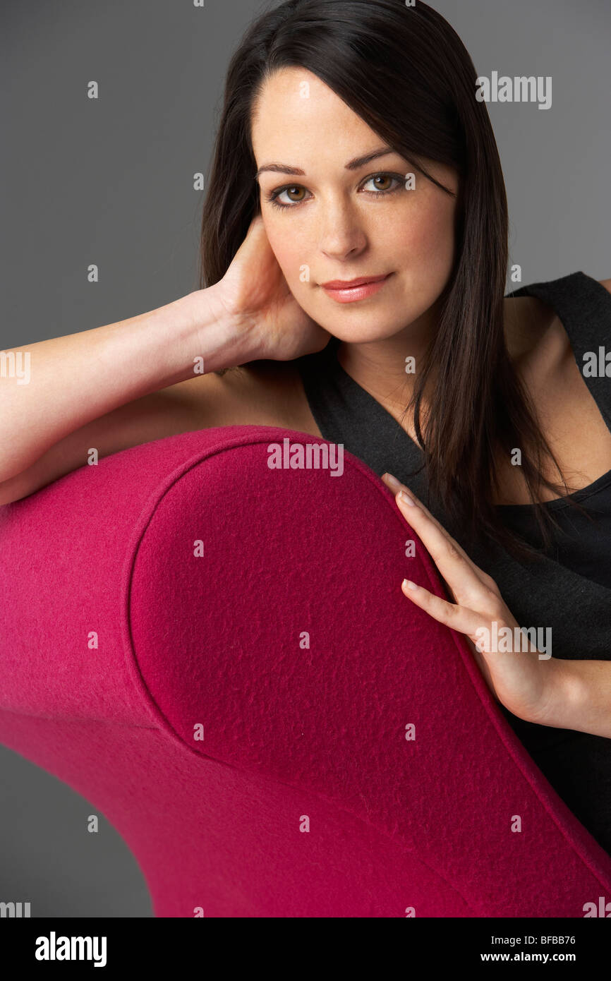 Studio ritratto di donna rilassante rosa sulla chaise longue Foto Stock