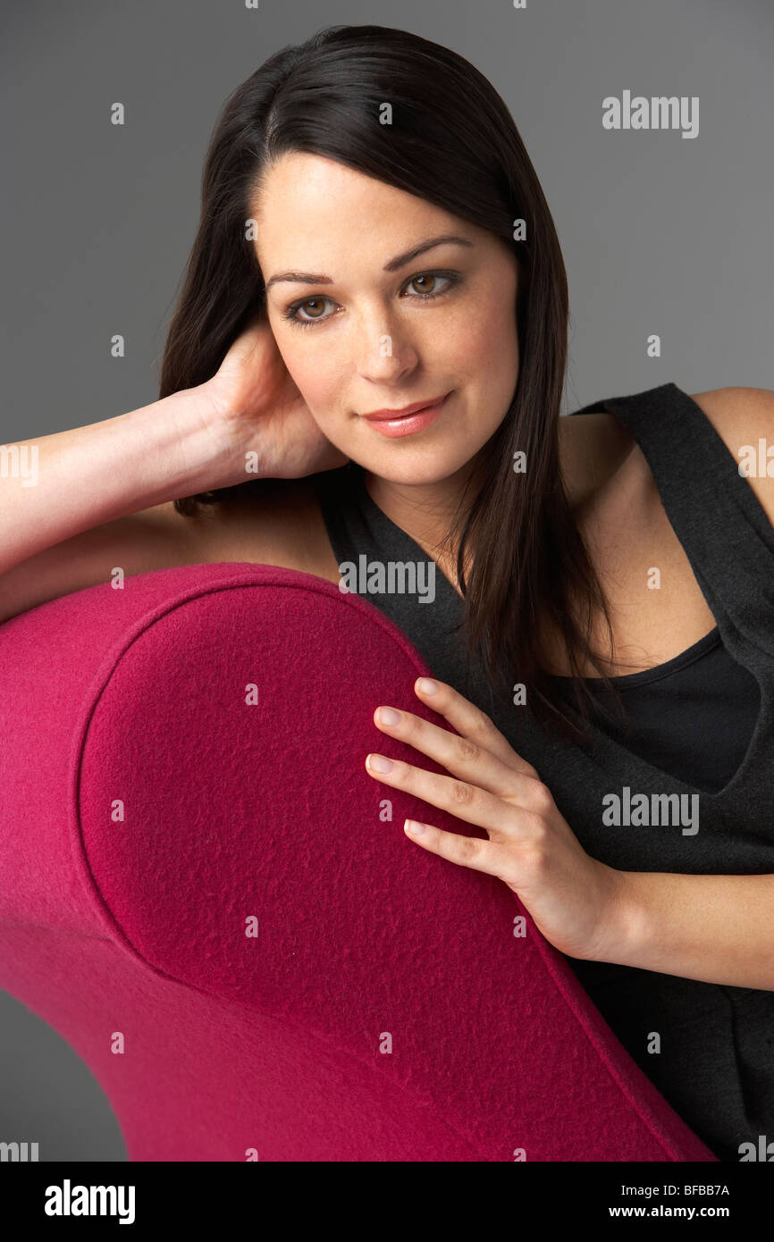 Studio ritratto di donna rilassante rosa sulla chaise longue Foto Stock