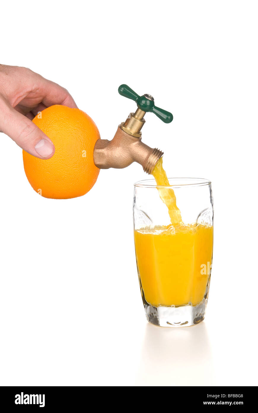 Un uomo detiene un arancione mentre il succo d'arancia fresco si riversa attraverso un rubinetto in un bicchiere. Foto Stock