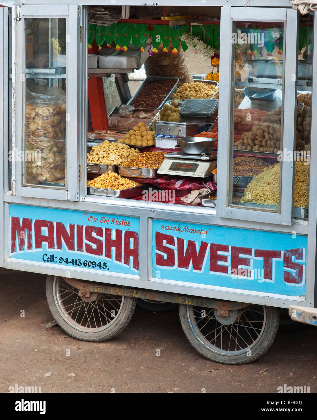 Carrello vendono dolci e spuntini su una strada. Andhra Pradesh, India Foto Stock