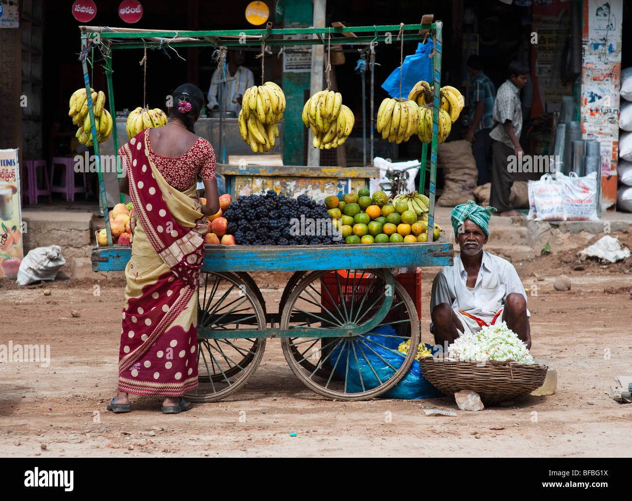 Wman indiana per la vendita di frutta da un carrello in un indiano street. Andhra Pradesh, India Foto Stock